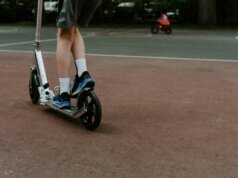 person in black and white nike sneakers riding blue and white skateboard during daytime