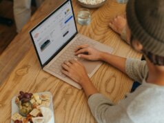 Person sitting on a table clicking on their Surface laptop