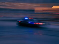 a police car driving down a street at night