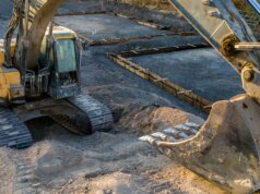 A small excavator sitting on top of a pile of dirt