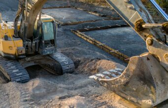 A small excavator sitting on top of a pile of dirt