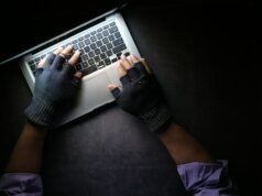 person in black long sleeve shirt using macbook pro