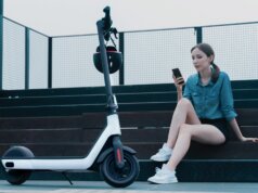 a woman sitting on steps next to a scooter