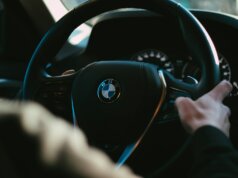 person holding black bmw steering wheel