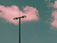 a street light sitting under a cloudy blue sky